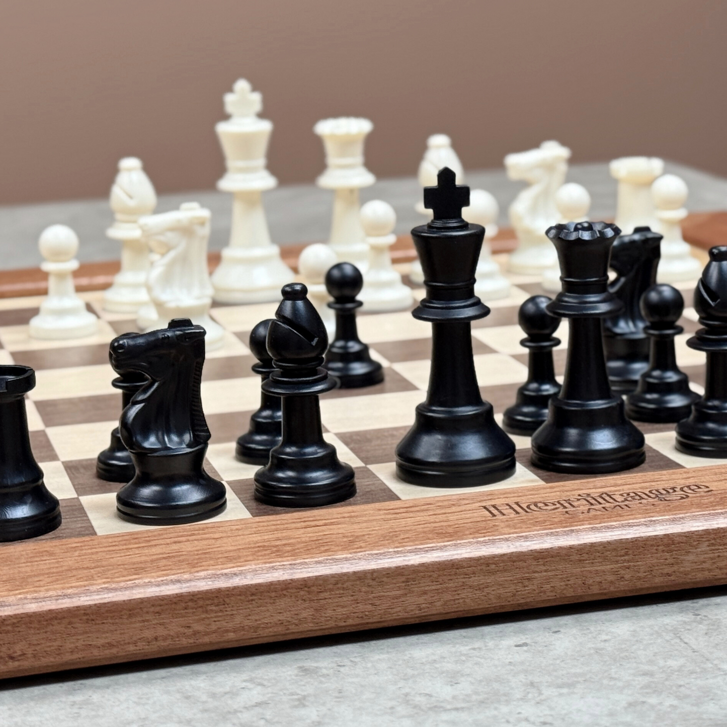 Wooden chessboard with black and white chess pieces on a neutral background