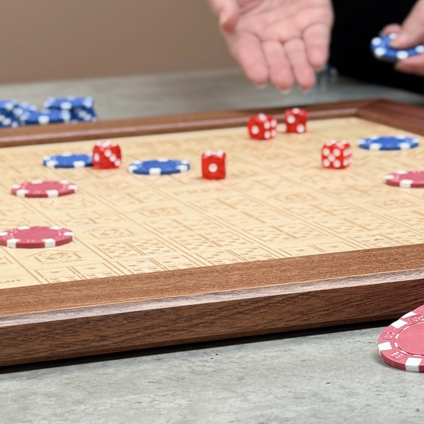 Close-up of a game board with dice and chips, indicating a game in progress.