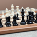 Wooden chessboard with black and white chess pieces on a neutral background